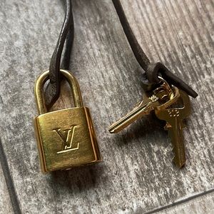 Louis Vuitton Lock and two keys on a brown leather strap